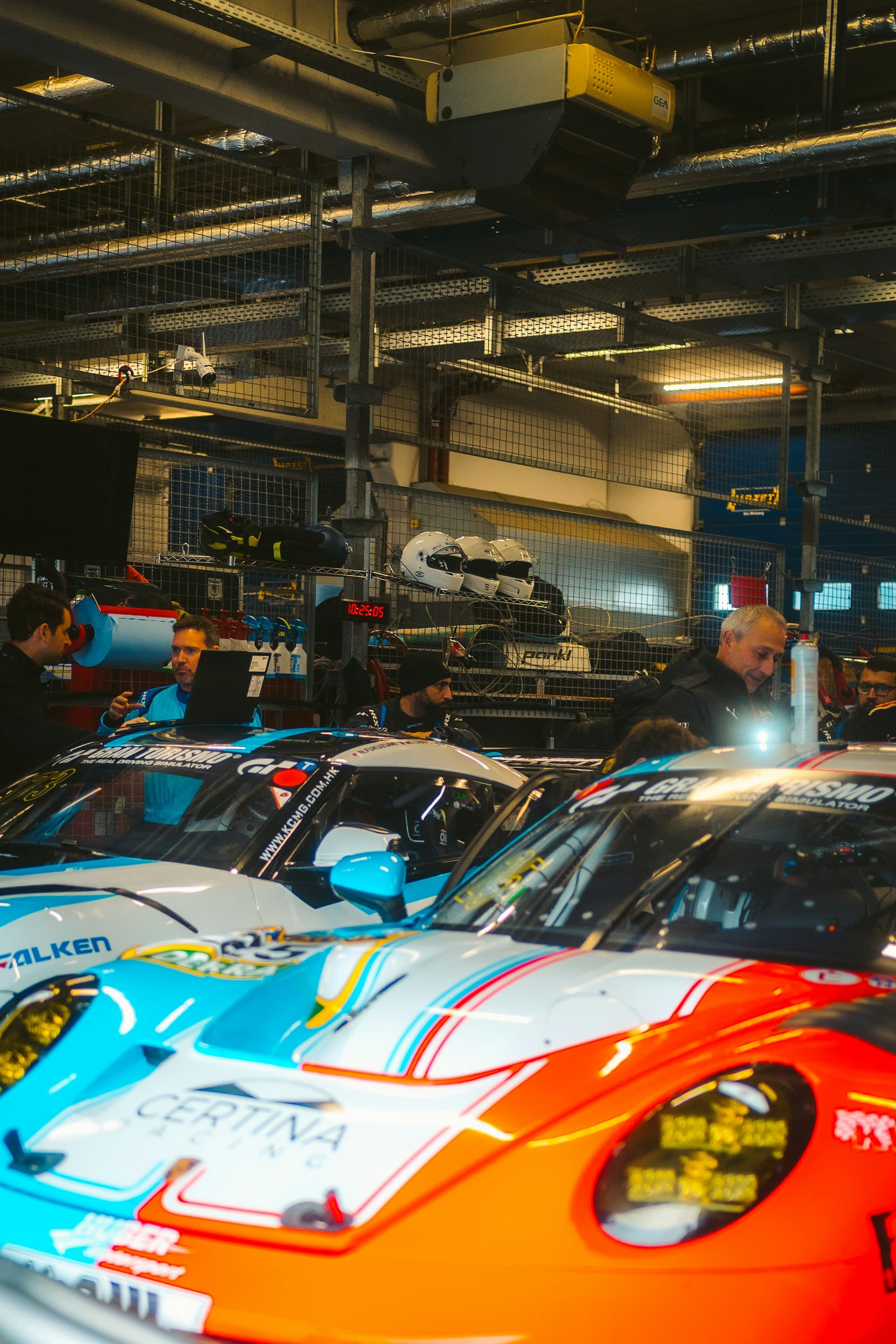 Race operation paddock with GT-class cars and crew